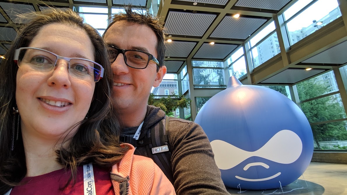 Anilu and Camoa in Drupalcon in front of the big drupicon